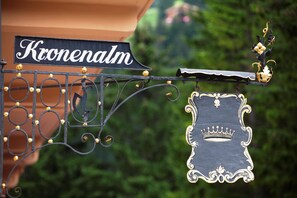 Un panneau portant le mot « Kronenalm » et un symbole de couronne, indiquant un lieu ou un établissement.