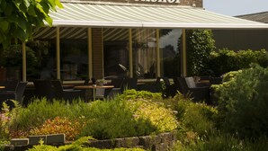 Un restaurant doté d’une terrasse et d’un jardin à l’avant.