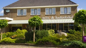 Un hôtel à deux étages, sur lequel on peut lire l’inscription « HÔTEL de Koekoekshof ».