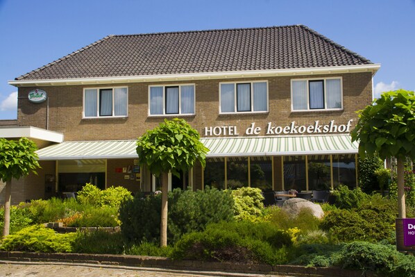 Un hotel di due piani con un cartello che riporta la scritta 'HOTEL de koekoekshof'.