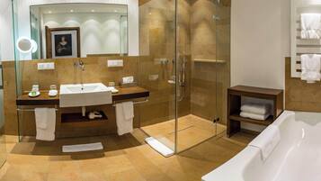 A modern bathroom with a glass-enclosed shower, a freestanding bathtub, and a vanity with a sink and mirror.