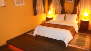 A hotel room with a bed, two bedside tables, and a nightstand.