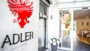A hotel entrance with a red lion emblem and the name 'ADLER' prominently displayed. - Adler Hotel & Gasthaus (Nonnenhorn)