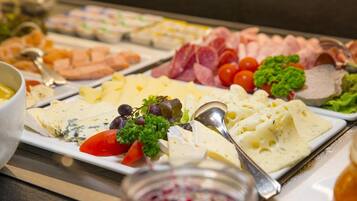 Un buffet proposant une variété de fromages, de viandes et de légumes.
