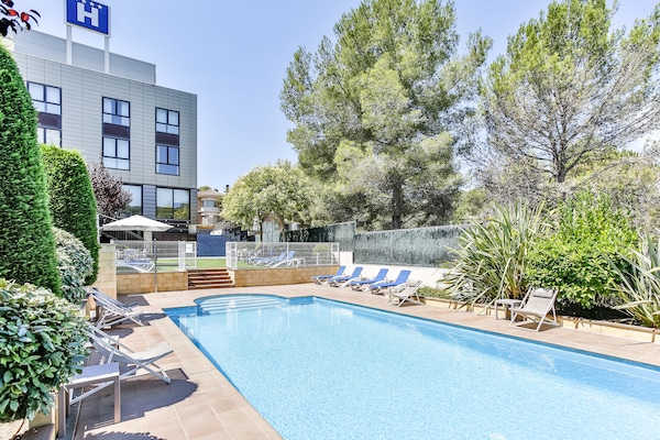 Una piscina al aire libre, sillones reclinables de piscina