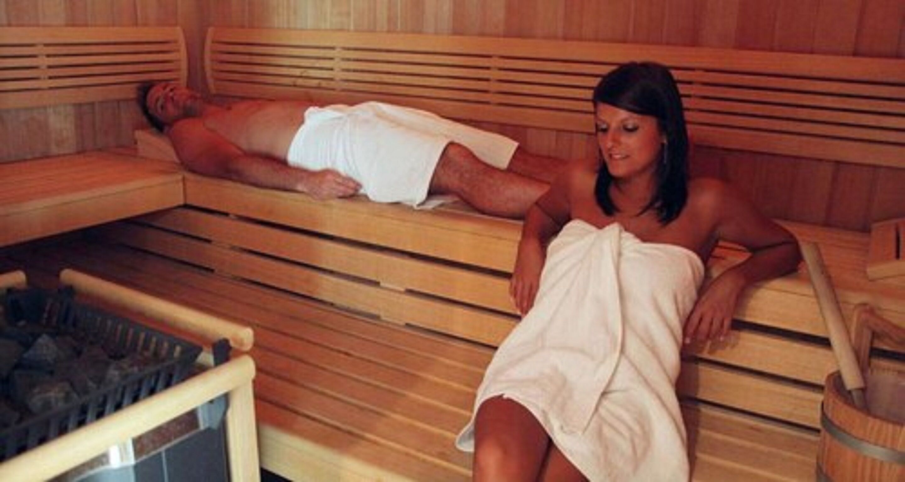 A sauna with wooden benches and a visible heating element.