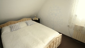 A bedroom with a bed, a nightstand, and a wall with a floral pattern. - Diamant- Guest House (Karlovy Vary)
