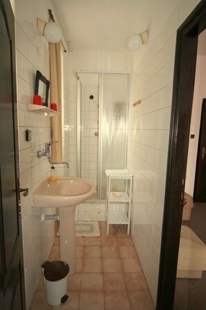 Habitación individual | Baño | Ducha, artículos de higiene personal gratuitos y secador de pelo