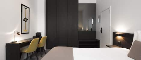 Una habitación de hotel moderna con cama, escritorio, sillas y armario.