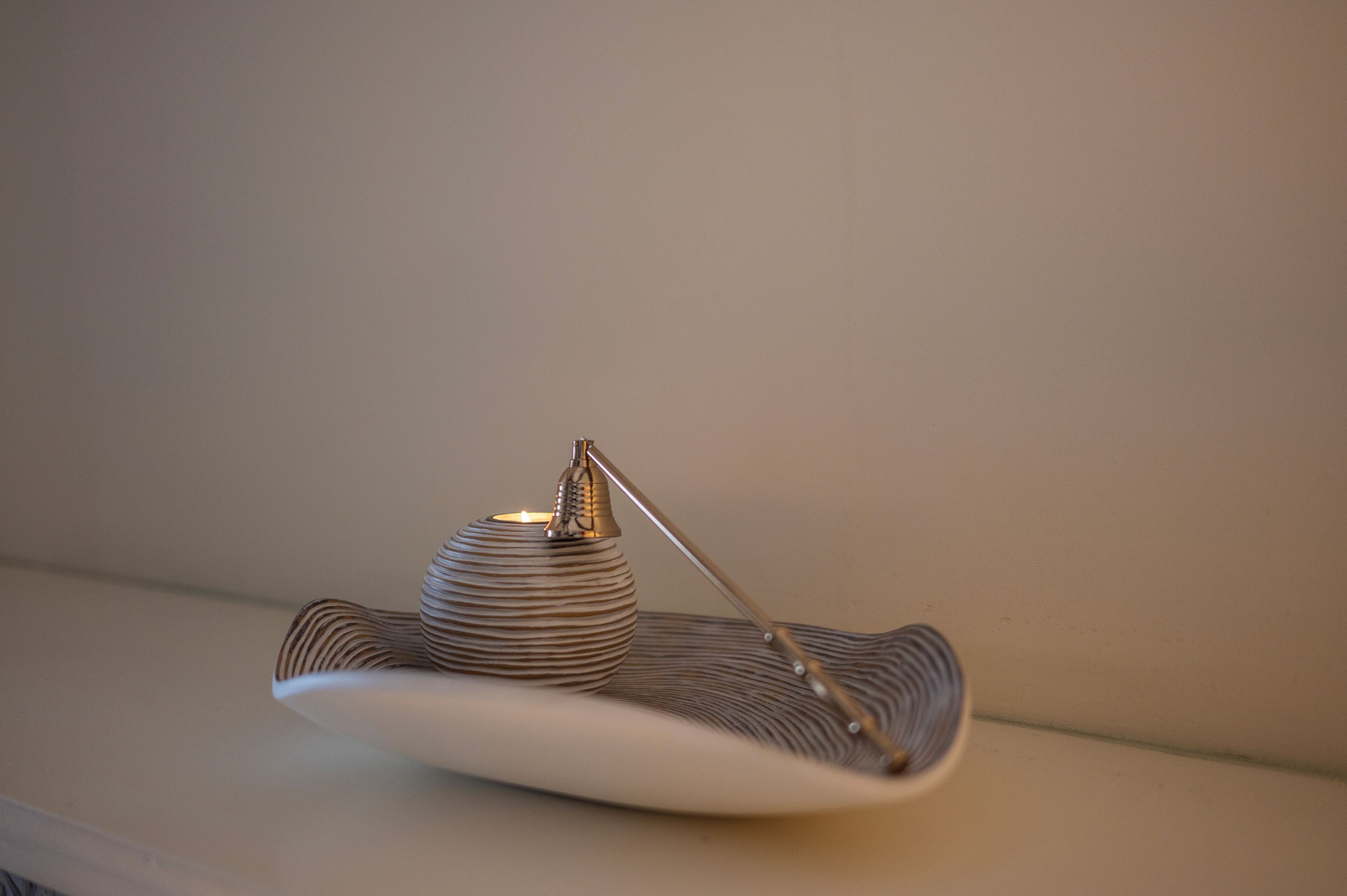 Une lampe de table moderne et minimaliste, dotée d’un socle métallique et d’un abat-jour incurvé à motifs en relief.