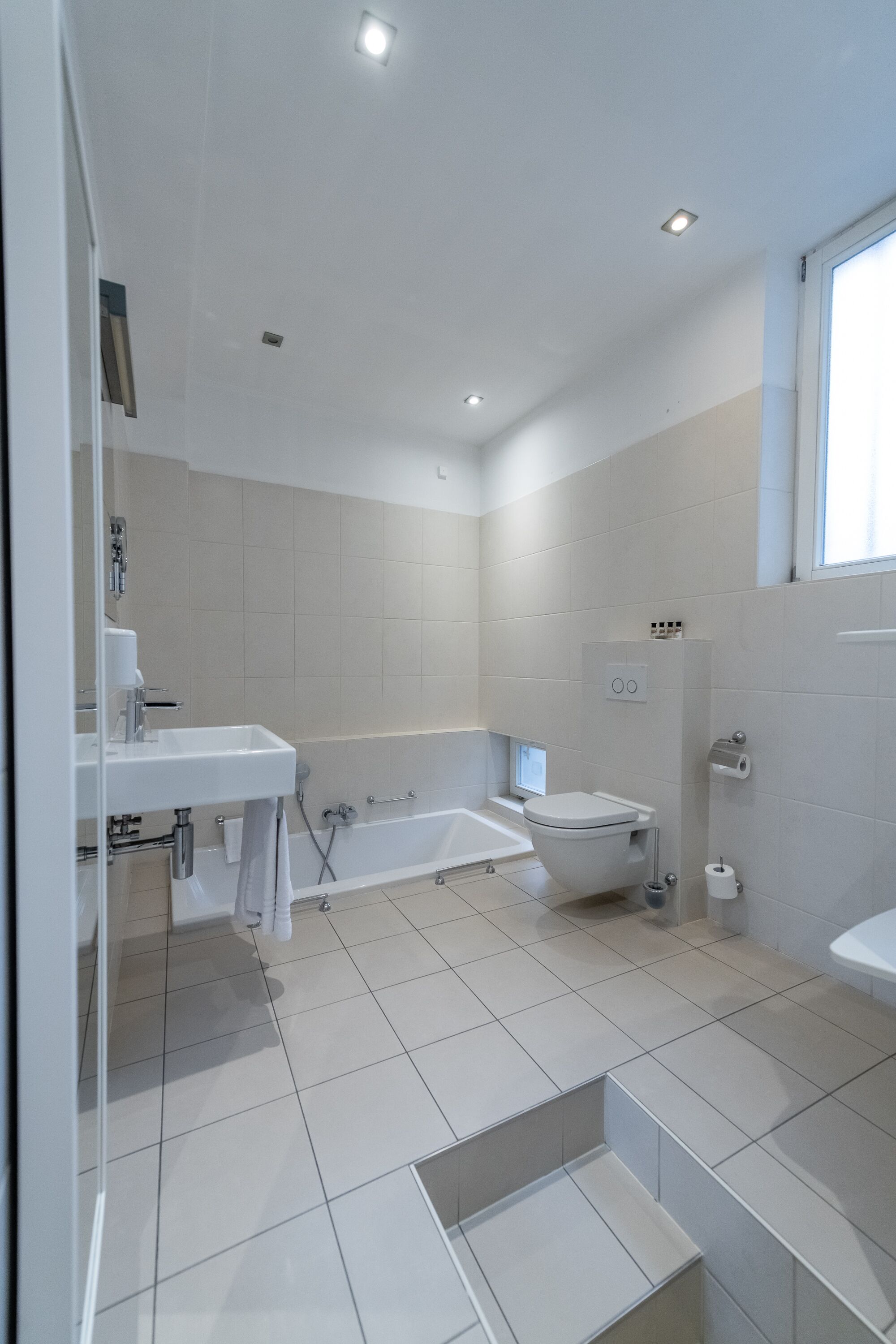Un bagno moderno con vasca, water e lavabo.