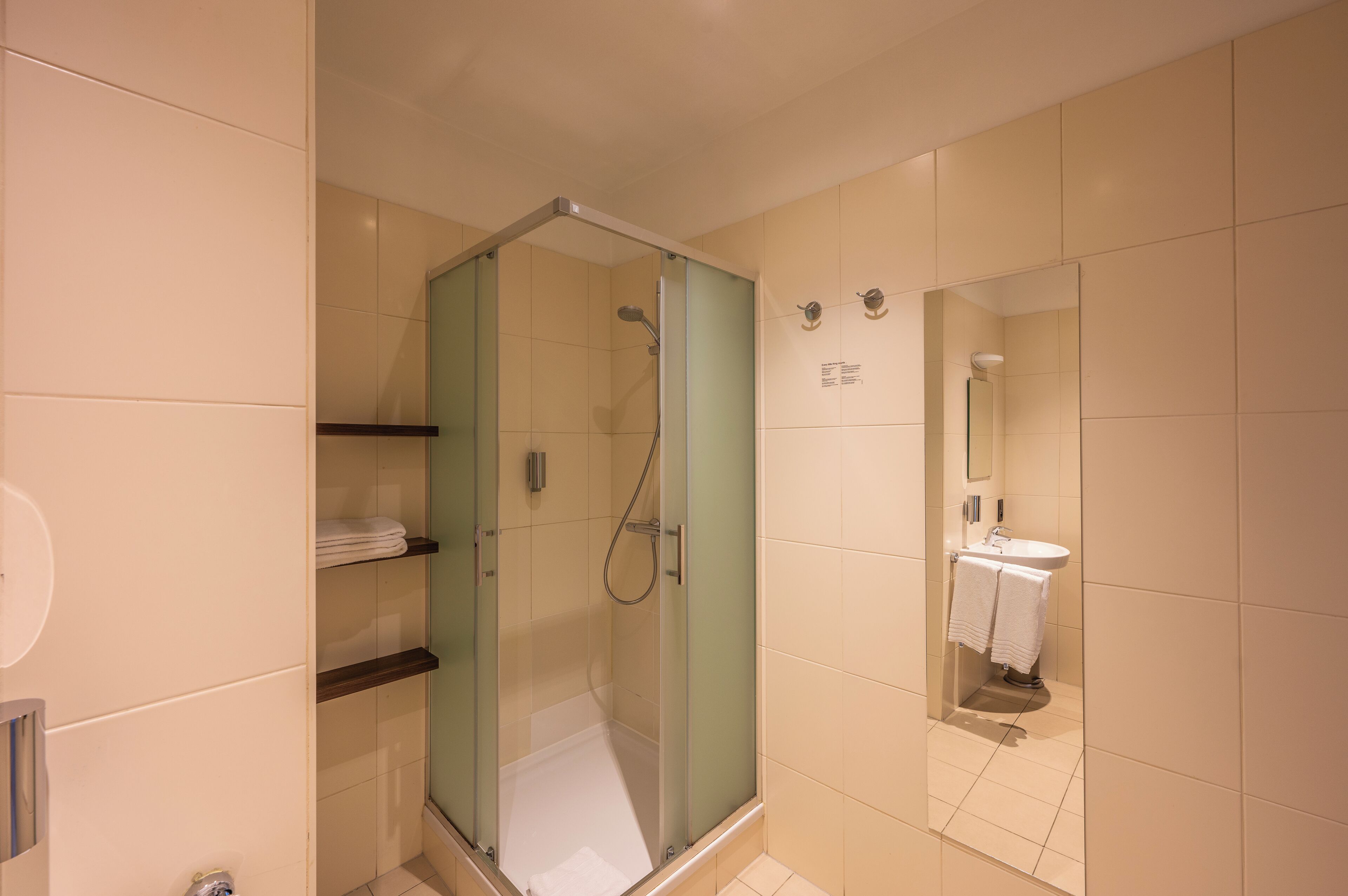 Un baño moderno con ducha de vidrio, inodoro y lavamanos.