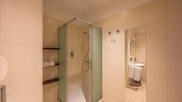 Un baño moderno con ducha de vidrio, inodoro y lavamanos.