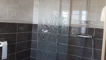 Une salle de bain moderne avec une douche à parois de verre, des toilettes et un lavabo.