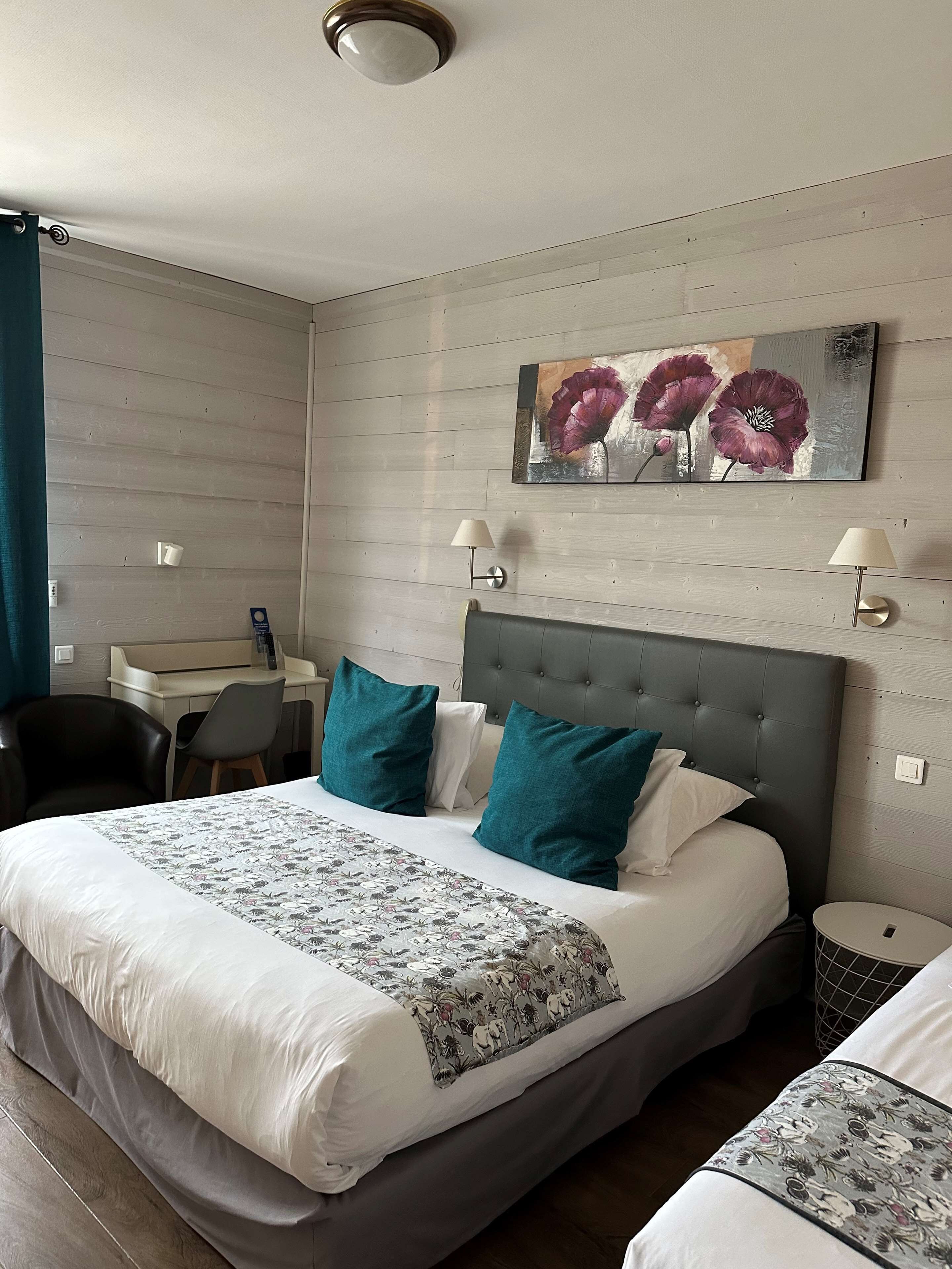 Een moderne hotelkamer met een groot bed, een bureau en een stoel.