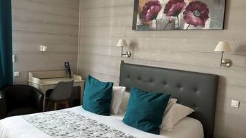 Een moderne hotelkamer met een groot bed, een bureau en een stoel.