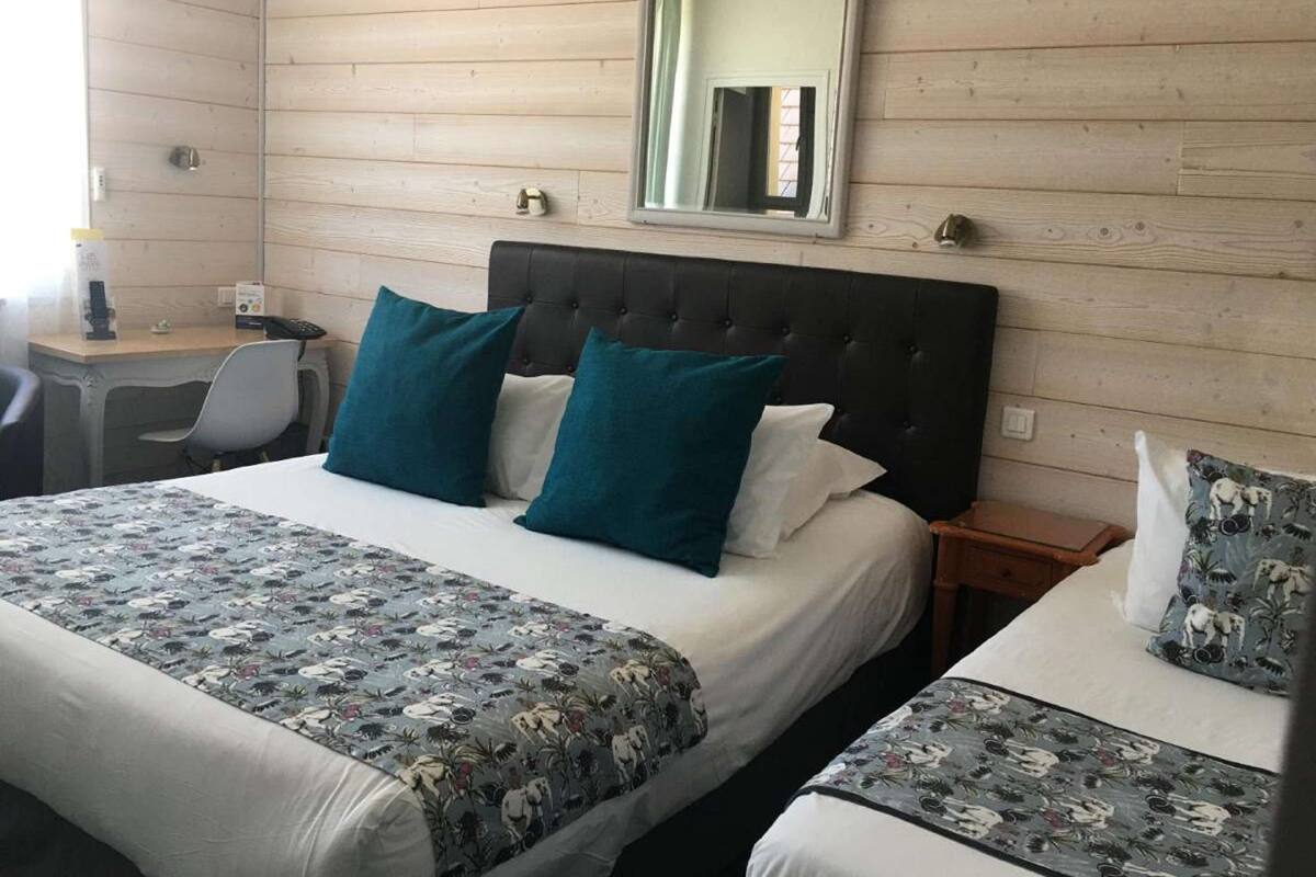 A hotel room with a bed, a desk, and a chair.