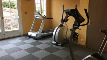 A gym with a treadmill, an elliptical, and a stationary bike.