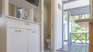 Un baño moderno con inodoro, lavamanos y espejo.