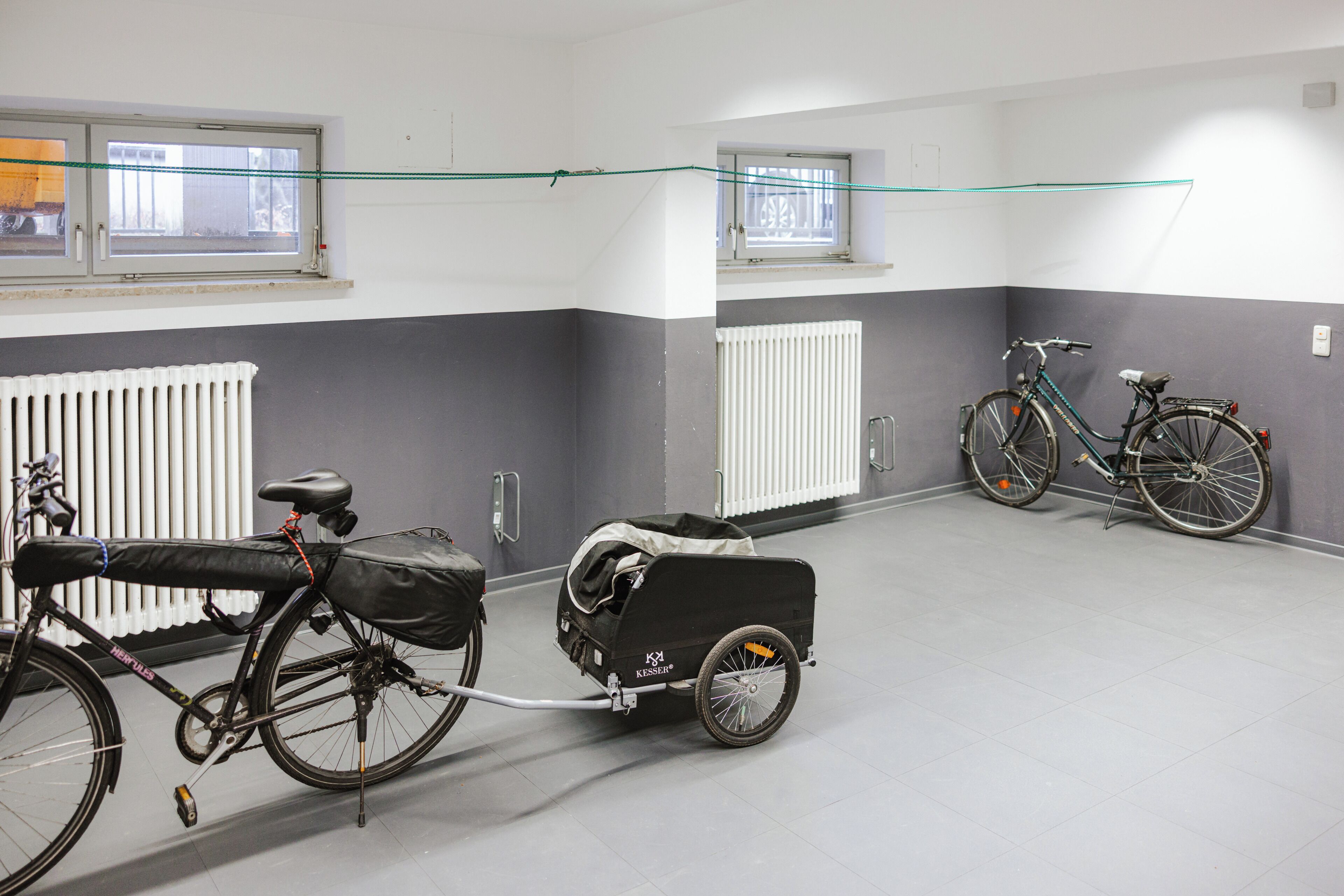 Una habitación con bicicletas, una silla de ruedas y un radiador.