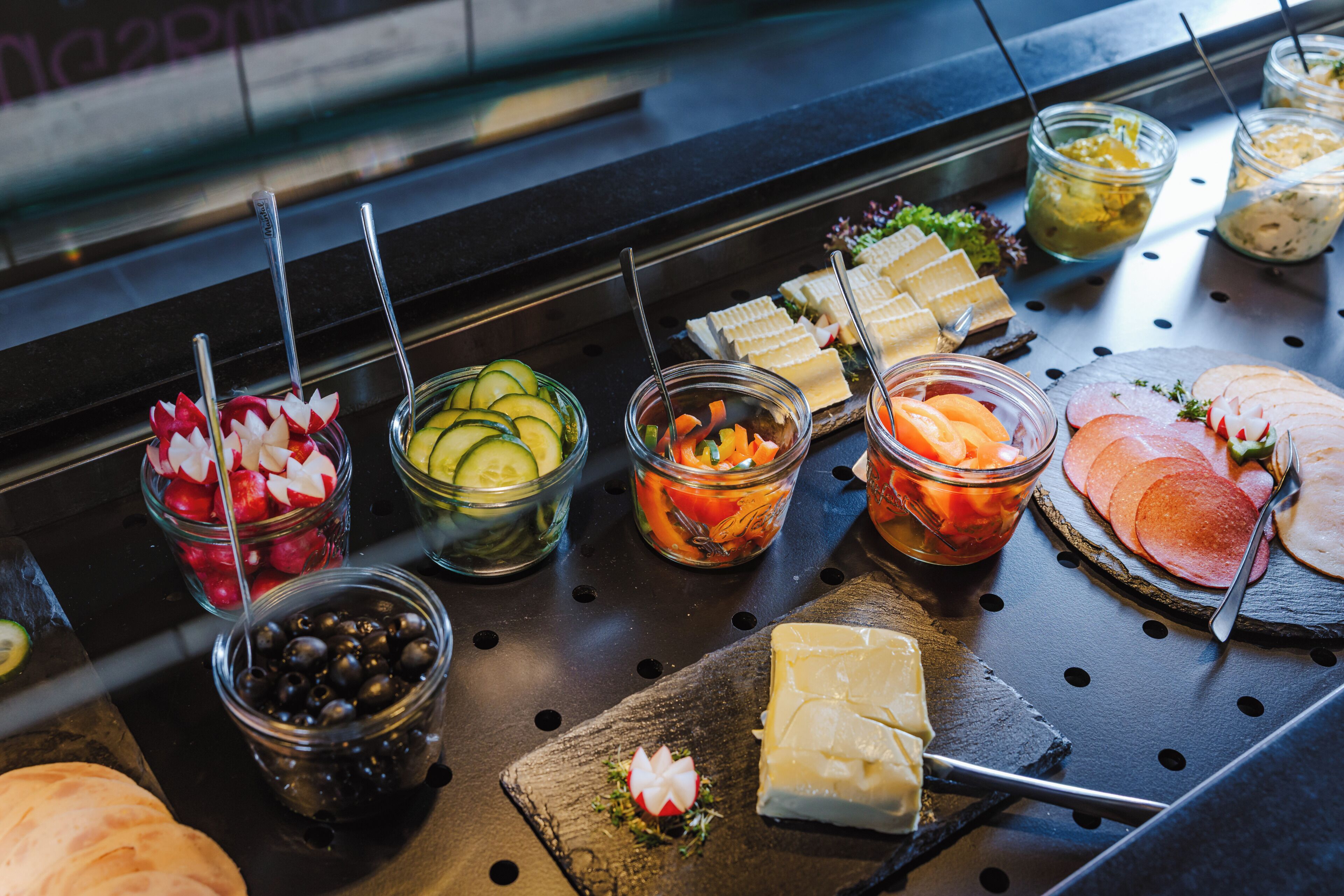 Un buffet proposant une variété de plats et d’ustensiles.