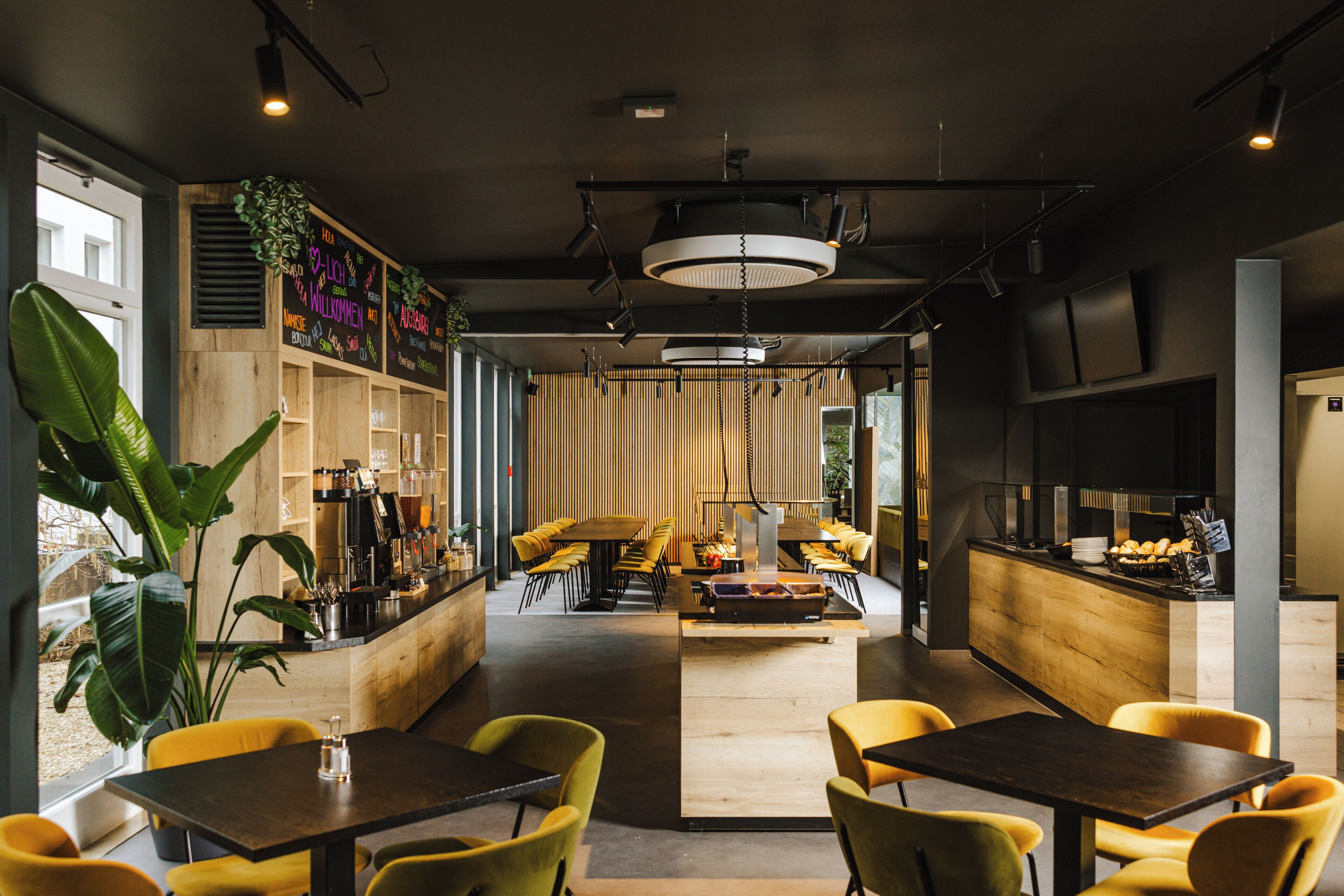 A modern interior with a central seating area, a bar, and large windows.