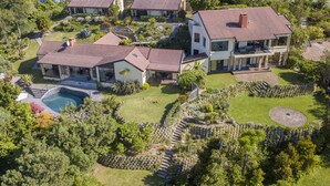 Un vaste domaine comprenant plusieurs maisons, une piscine et des jardins aménagés.