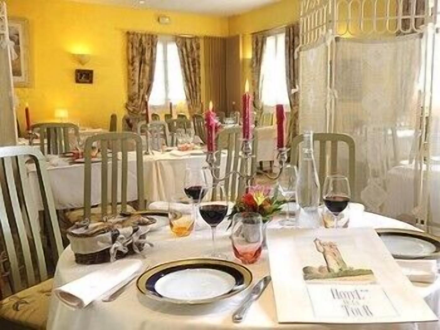 A dining table set for a meal with a menu, glasses, and cutlery.