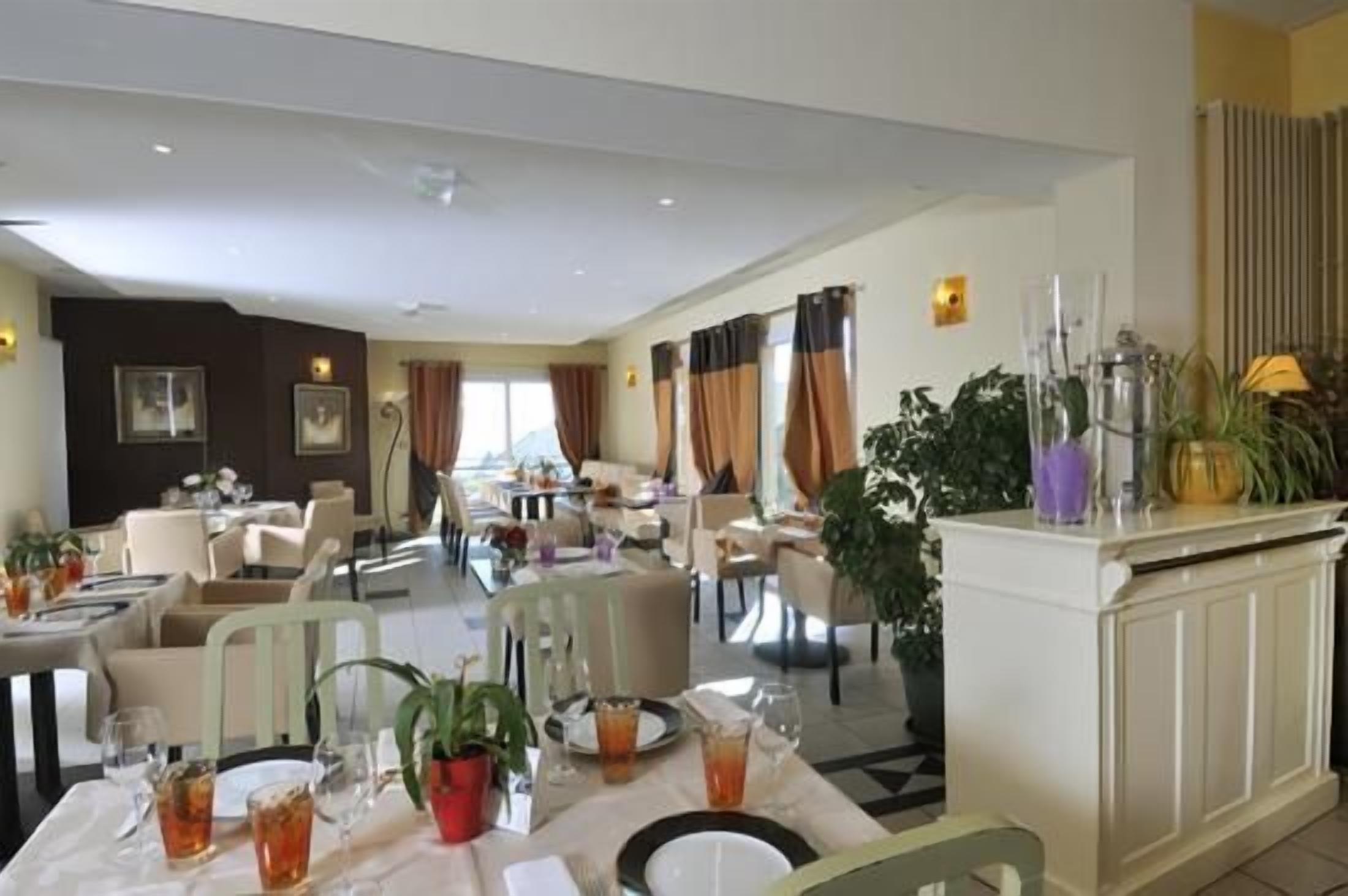 A hotel dining area with tables set for guests, a reception desk, and a view of the cityscape.