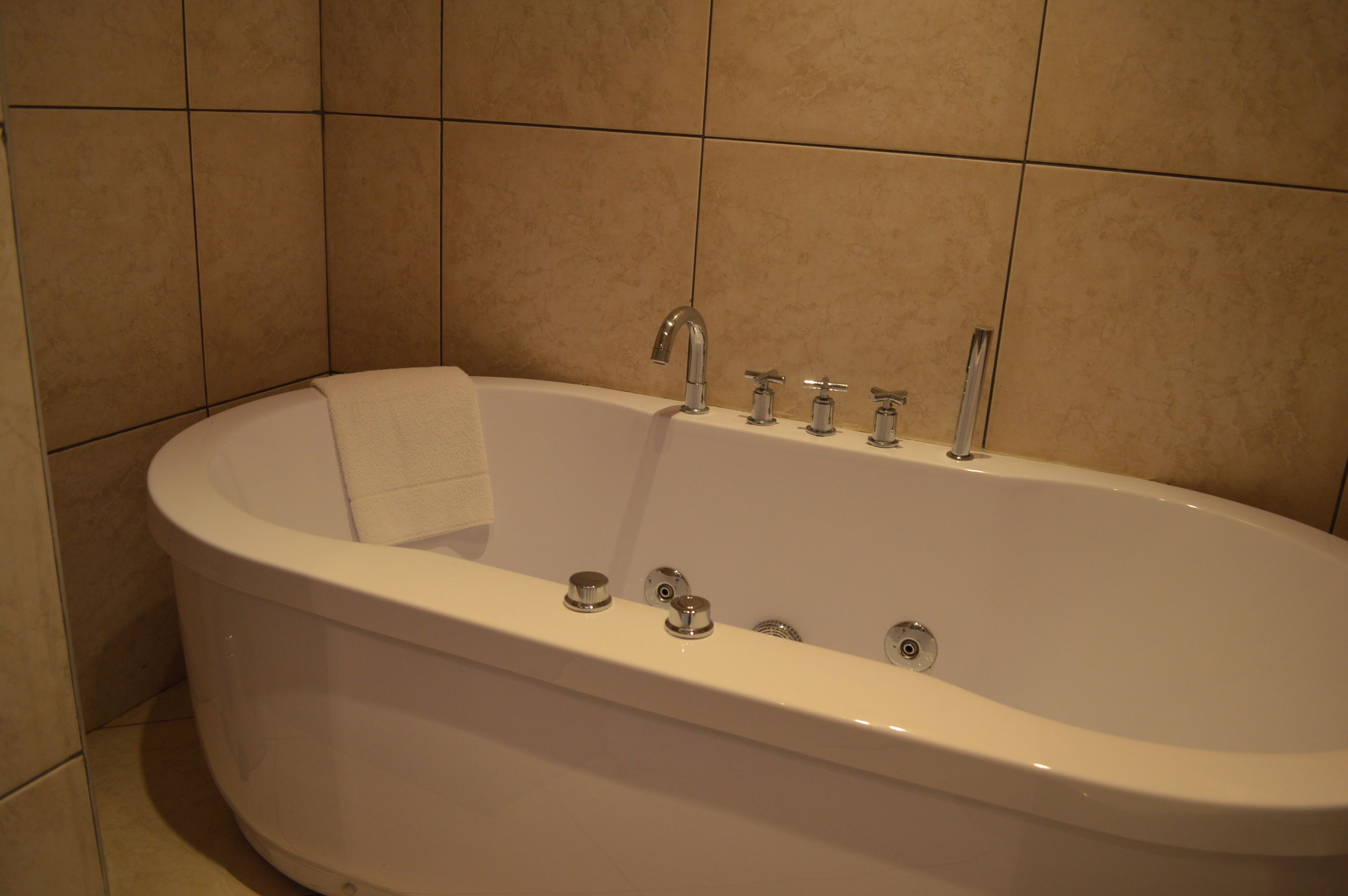 Ein modernes Badezimmer mit einer freistehenden Badewanne, einer Handbrause und einer integrierten Armatur.