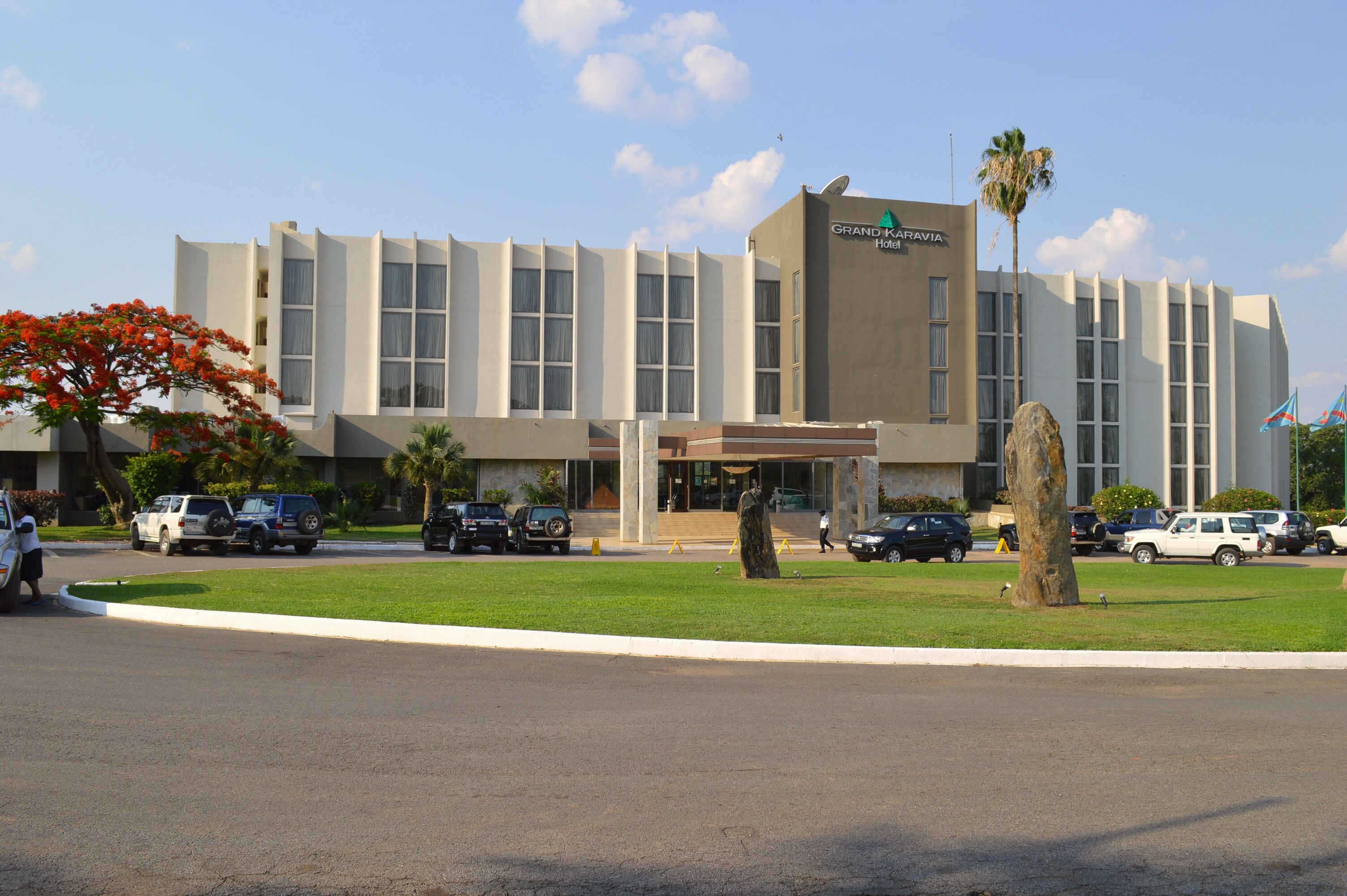 A modern hotel with a flat roof, large windows, and a central entrance.