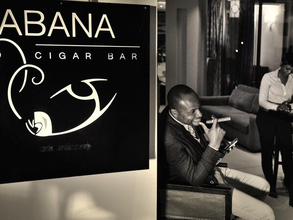 Skilt for 'ABANA CIGAR BAR' med en stiliseret logo.
