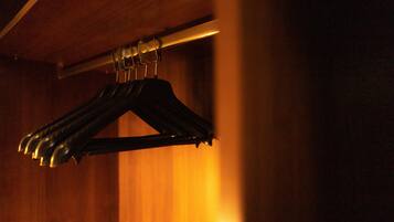 A set of black hangers hanging on a metal rod.