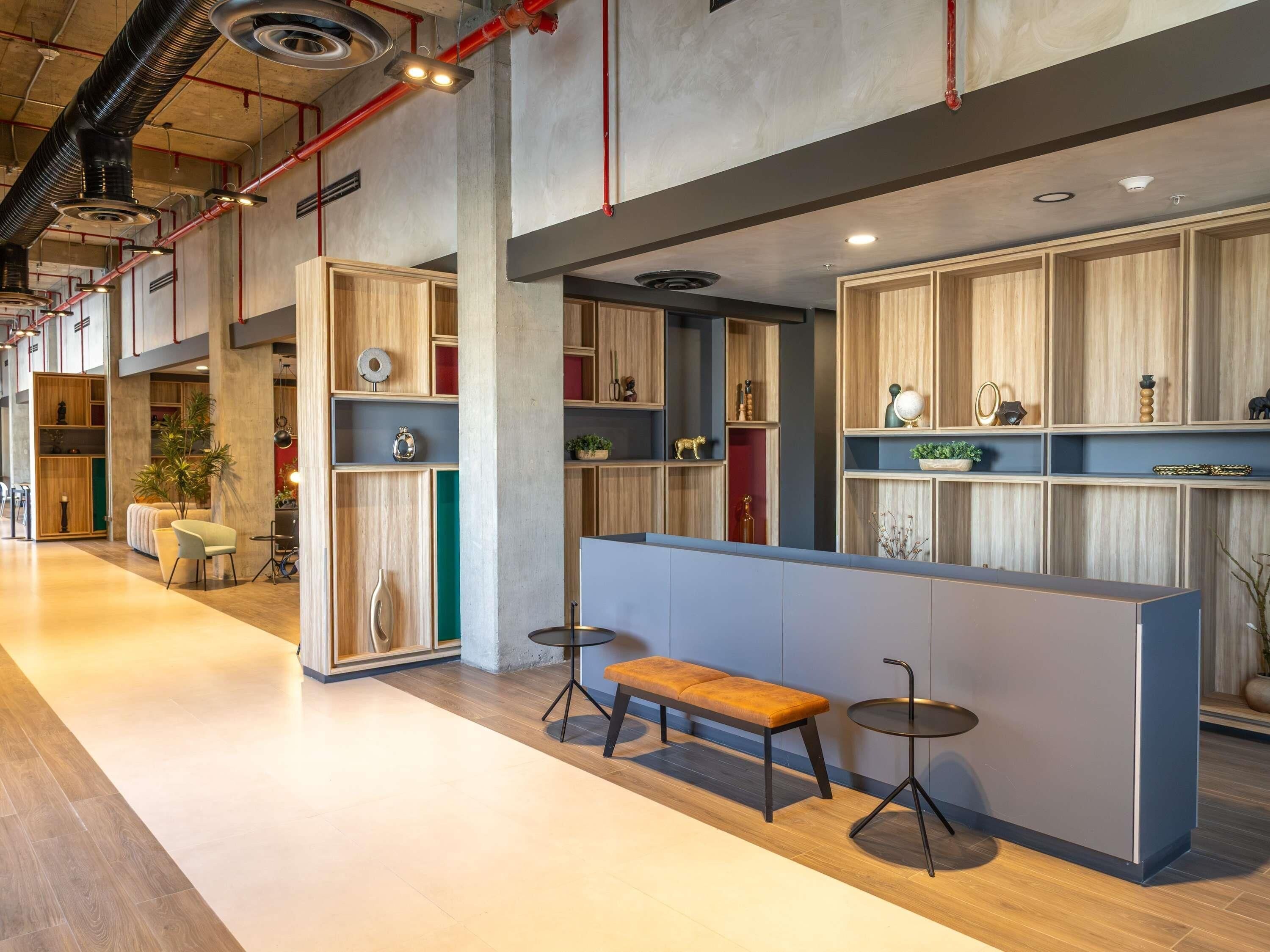 Un interior moderno con una zona de estar, estanterías de madera y un banco.