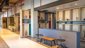 Un interior moderno con una zona de estar, estanterías de madera y un banco.