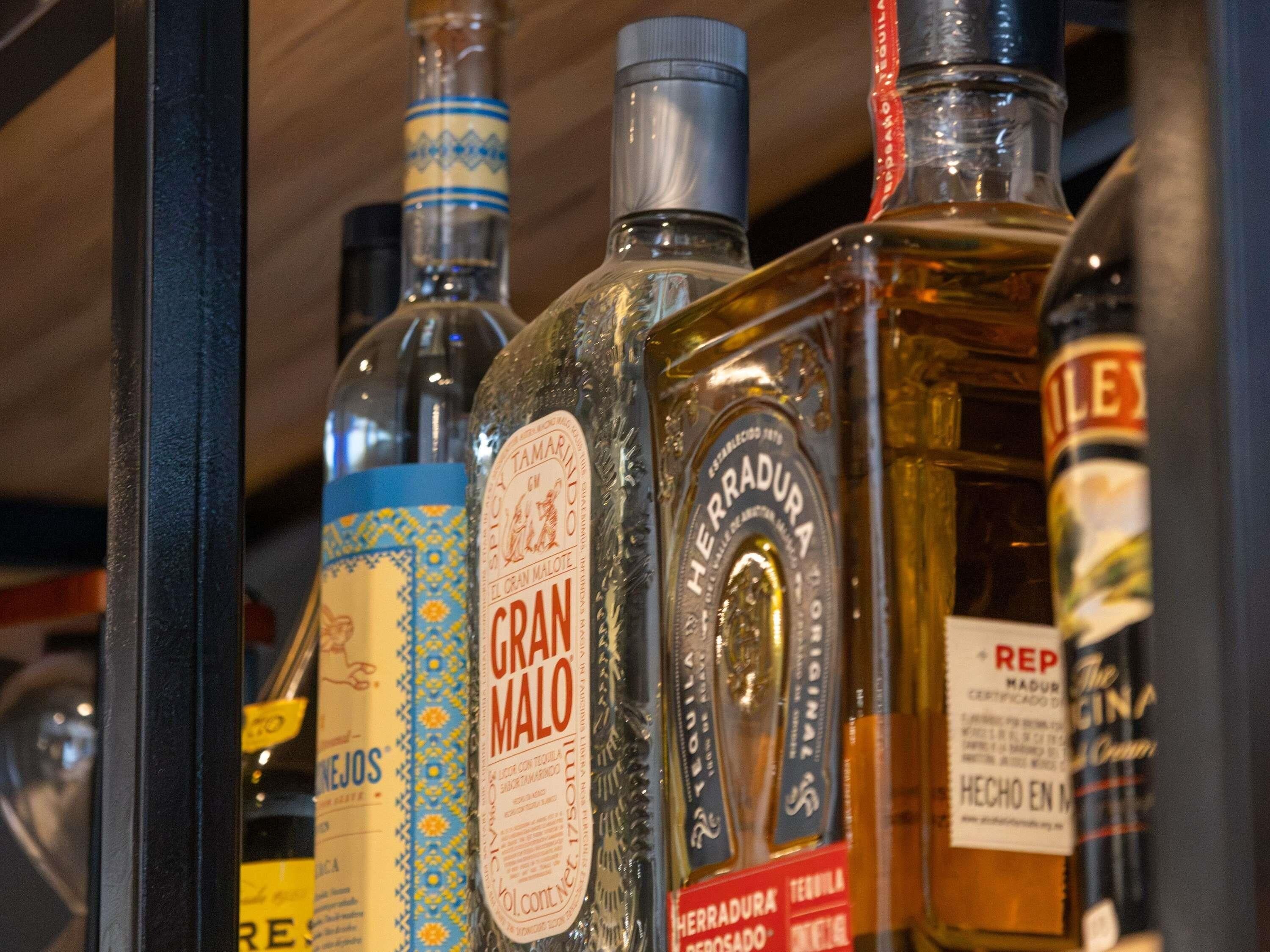 A variety of liquor bottles displayed on a shelf.
