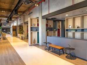 A modern interior with wooden shelving units, a bench, and a round table.