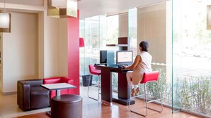 A modern interior with a desk, computer, and seating area. - ibis Hermosillo (Hermosillo)