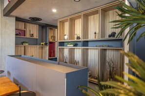 Un interior moderno con estanterías de madera integradas, una zona de estar con un banco y diversos objetos decorativos.