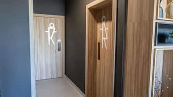 A hallway with two wooden doors, one with a wheelchair accessibility symbol.