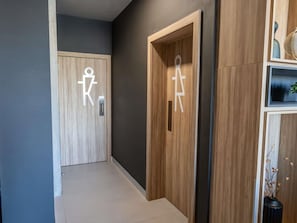 En hall med två trädörrar, varav en har en symbol som visar att den är anpassad för rullstolsburna.
