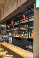 Zona de bar con estanterías que muestran equipo deportivo, botellas y una barra.