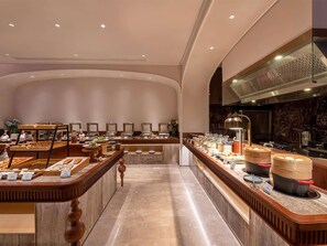 A buffet area with various food items and a kitchen in the background. - Mercure Xi'an High-tech Zone Center (Xi'an)