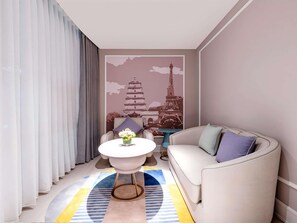 Una camera d'hotel moderna con un divano, un tavolino rotondo e un murale decorativo.