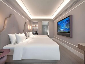A modern hotel room with a large bed, a flat-screen TV mounted on the wall, and a small desk with a chair. - Mercure Xi'an High-tech Zone Center (Xi'an)