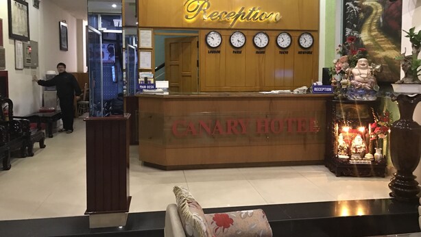 A reception desk with clocks displaying times for London, Paris, Hong Kong, Tokyo, and New York. - Canary Hotel Hue (Hue)
