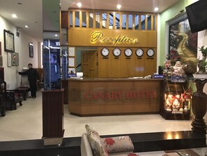 A reception desk with clocks displaying times for London, Paris, Hong Kong, Tokyo, and New York. - Canary Hotel Hue (Hue)