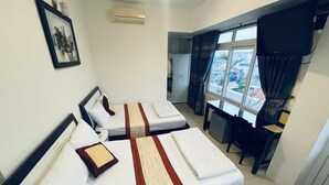 A hotel room with two beds, a desk, a chair, a TV, and a window with curtains. - Canary Hotel Hue (Hue)