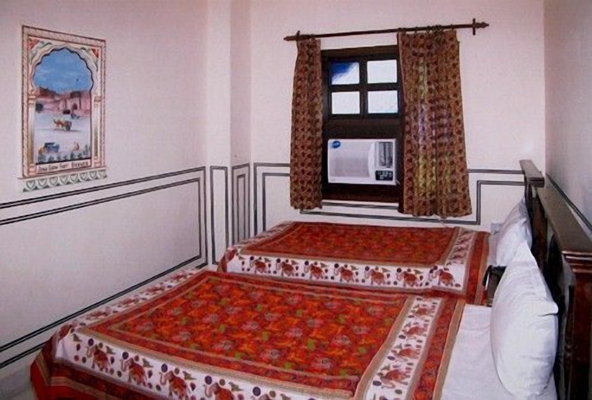 A bedroom with two beds, a window with curtains, a wall-mounted air conditioner, and a framed picture.