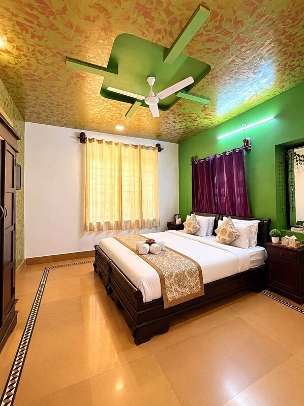 Un dormitorio con cama, cortinas, ventilador de techo y pared verde.